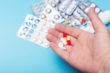 medical tablets in the hand of a person on the background of medicines