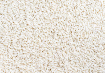 Unprepared white rice as a background. Top view.