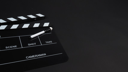 Fototapeta na wymiar Pen with Clapperboard or clap board or movie slate use in video production ,film, cinema industry on black background.