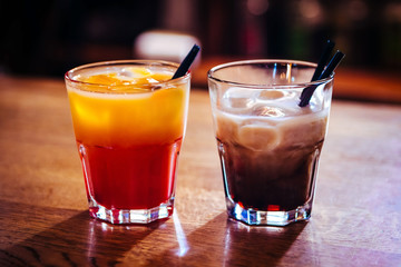 Different alcoholic cocktail with ice in a bar on a wooden table