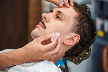 Barber closing mans pores with alum stone. Traditional ritual of after shaving the beard with alum...