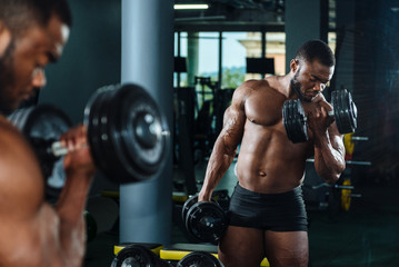 Male athlete, bodybuilder, working out in the gym