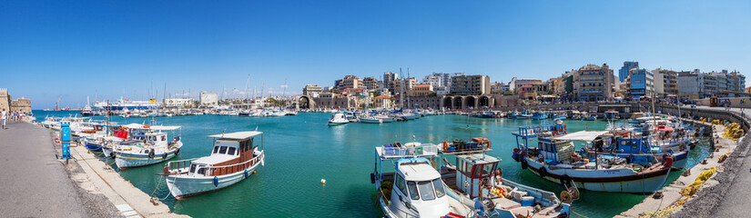 The harbor of Heraklion with ruins of Venetian era buildings and numerous yachts and boats in port, Crete, Greece.