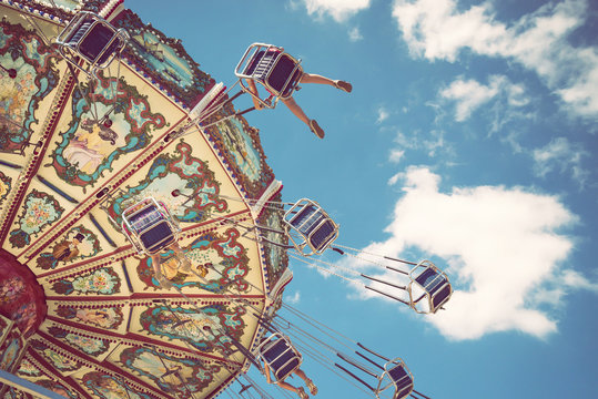 Wave Swinger ride against blue sky and white clouds