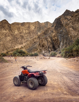 Active leisure in Egypt on ATV quads in the stone desert, moto safari on dirt road in a canyon on Sinai Peninsula.