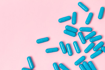 Blue pills at pink background.Flat lay. Empty place for text.