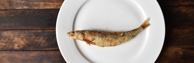 fried battered fish on wooden table top view