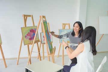 two young asian woman artist figure is sitting the drawing. using ideas to think and elaborate on...
