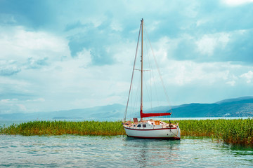 North macedonia. Ohrid. White sailboat on Ohrid lake beside reeds in sunny day