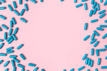 Blue pills at pink background.Flat lay. Empty place for text.