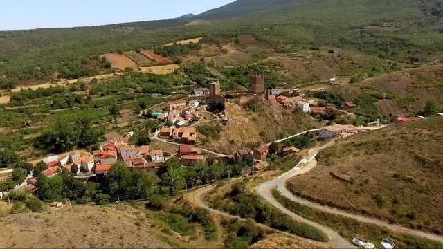 Aerial drone footage of medieval Aragon village of Vozmediano and castle ruins with Moncayo mountains in the background .