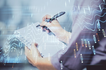 Multi exposure of hands making notes with forex chart huds. Stock market concept.