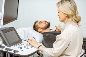 Obraz premium Doctor examining men's thyroid with ultrasound