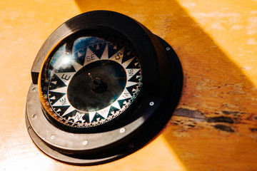 Ship black compass on wood background