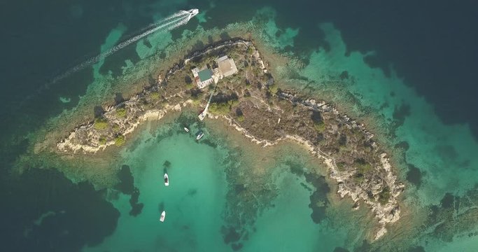 Halkidiki, Greece : boats and yachts moored near the private island  in a secluded location on the Aegean sea. View from drone