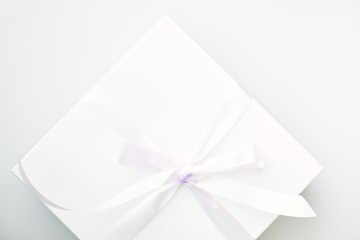 Closeup of cakes in white boxes tied with purple ribbon with a label