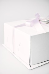 Closeup of cakes in white boxes tied with purple ribbon with a label
