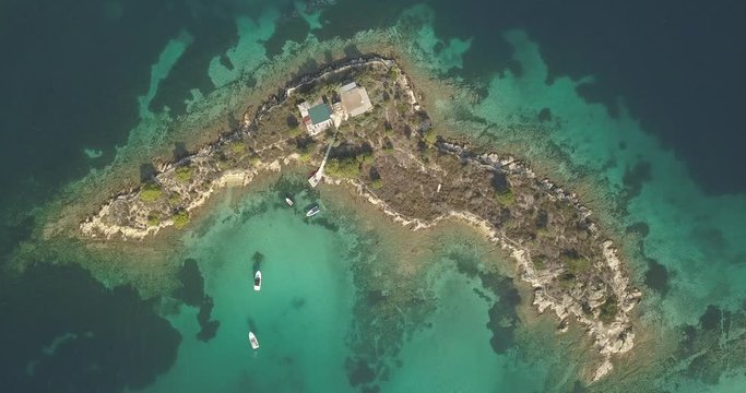 Halkidiki, Greece : boats and yachts moored near the private island  in a secluded location on the Aegean sea. View from drone