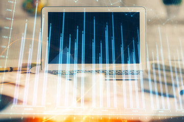 Stock market chart hologram drawn on personal computer background. Multi exposure. Concept of...