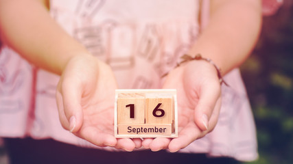 September 16th. Image of september 16 wooden office calendar in teen girl hand background. Autumn day