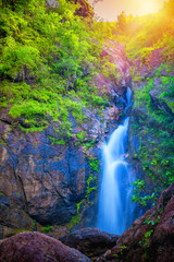 Fototapeta na wymiar Beautiful waterfall with sunlight rays in deep forest, Landscape scenery of Jogkradin waterfall in Kanchanaburi, Thailand.
