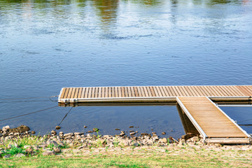 Wood pier with blue lake or river on background