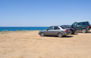 Plakat Cars stand on the beach in a clear summer afternoon, an impromptu Parking lot came to rest the owners of cars , copy space.