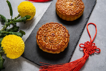 Chinese Mid-Autumn Festival cuisine, moon cakes and chrysanthemums on red background