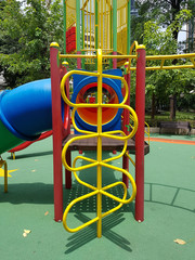 Metal climbing ladder in front of a kid's tube slider entrance