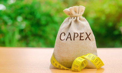 Money bag with the word Capex ( capital expenditure ) and tape measure. Capital used by companies...