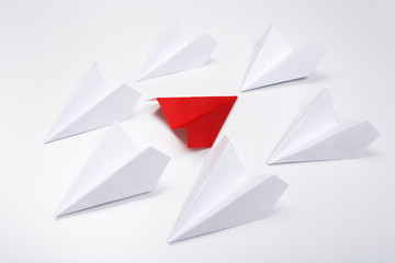 Group of white paper plane in one direction and one red paper plane pointing in different way on white background. Business for innovative