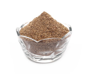 Ground carob powder in glass bowl (Ceratonia siliqua) isolated on white background