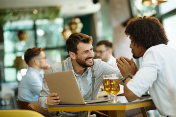 Men are sitting at table in modern cafe. Talk about work