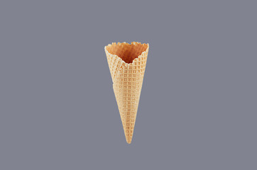 Empty  waffle ice cream cone on soft light  grey background, mock up for advertising, design, menu, summer food.