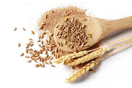 Spelt bran and grains with wooden spoon and ears of wheat isolated on white background, top view