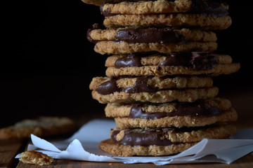stack of cookies with chocolate on wooden background