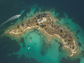 Naklejka na ściany i meble Halkidiki, Greece : boats and yachts moored near the private island in a secluded location on the Aegean sea. View from drone