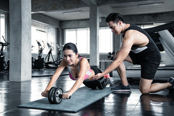 Obraz premium Sexy asian woman workout by ab wheel.