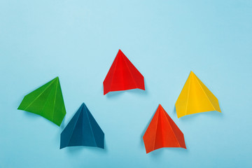 Color paper airplanes on blue background. Different vision creative and Innovative solution for Business concepts.