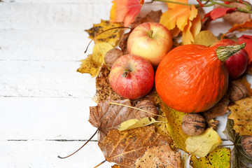 autumn composition with copy space on white wood background, pumpkin, apples and leaves