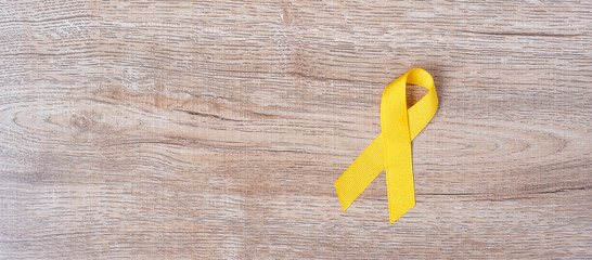 Suicide prevention and Childhood Cancer Awareness, Yellow Ribbon for supporting people living and illness. children Healthcare and World cancer day concept