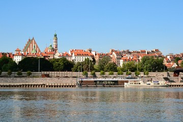 Scenic view of the Old Town - historic quarter of Warsaw with Royal Castle and red roof tenements seen from the Vistula river side. Warsaw, Poland