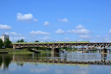 Warsaw, Poland. The geen and yellow train crossing the Srednicowy Bridge in Warsaw, Poland. It is a railway bridge over the Vistula River in Warsaw, north of the Poniatowski 