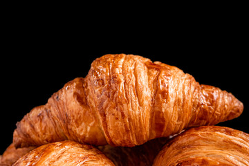 Fresh fragrant crispy french croissants on a black background with copy space. Delicious pastries for a refined breakfast
