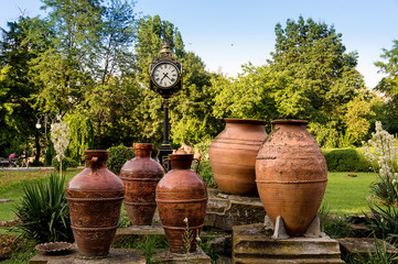 An old clock surrounded by a group of amphorae in the Cismigiu Park of Bucharest (Romania).