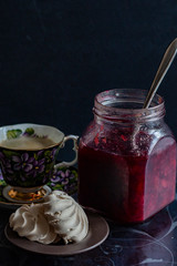 jam in a jar, tea and cake on a dark background