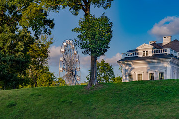 Ferris wheel and part of the facade of the building against the blue sky