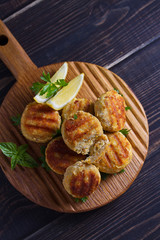Fish cakes. Fish patties. Fried cutlets of minced fish on serving board. View from above, top studio shot