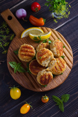 Fish cakes. Fish patties. Fried cutlets of minced fish on serving board. View from above, top studio shot