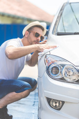 Close up of man polishing his car with microfiber cloth.
